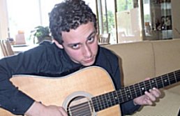 Dan Kaplan coyly looking up from his guitar