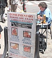 A man on the side of the street offering a free foot examination.