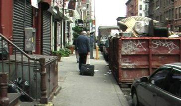 Jim Brochu on 37th street wheeling luggage